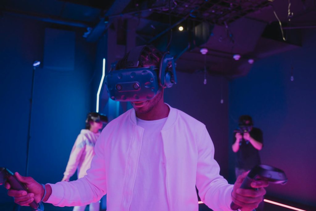 A man in a VR headset explores a virtual reality space indoors, immersed in gaming technology.